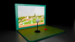 Thumbnail: A golf-ball-shaped control stands before a turquoise screen housing and pixel-game image.