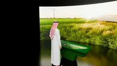 Thumbnail: Curved landscape screen behind a long green interaction table and a scale figure.