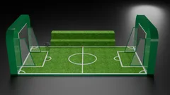 Thumbnail: A miniature football-pitch installation with two netted goals, tall end screens, marked turf and a stepped spectator bench.