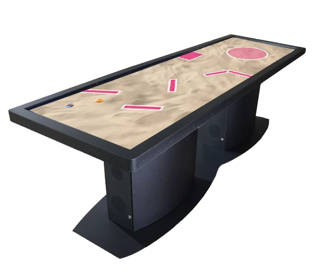 A long game table with a sand-colored playing surface and pink obstacles.