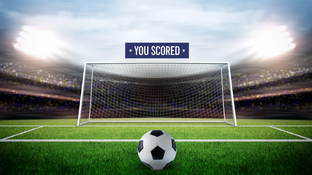Football game result screen showing a ball, goal, stadium and You Scored message.