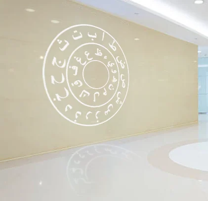 White Arabic letters arranged in concentric circles on a pale curved interior wall.