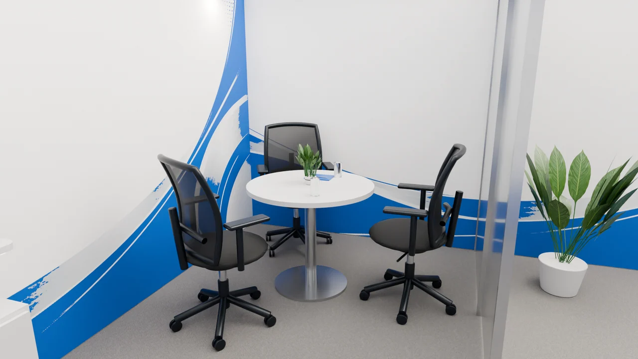 The meeting area combines dark chairs, a pale tabletop, metallic furniture bases and a glass partition.