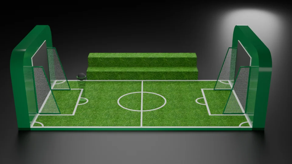 A miniature football-pitch installation with two netted goals, tall end screens, marked turf and a stepped spectator bench.